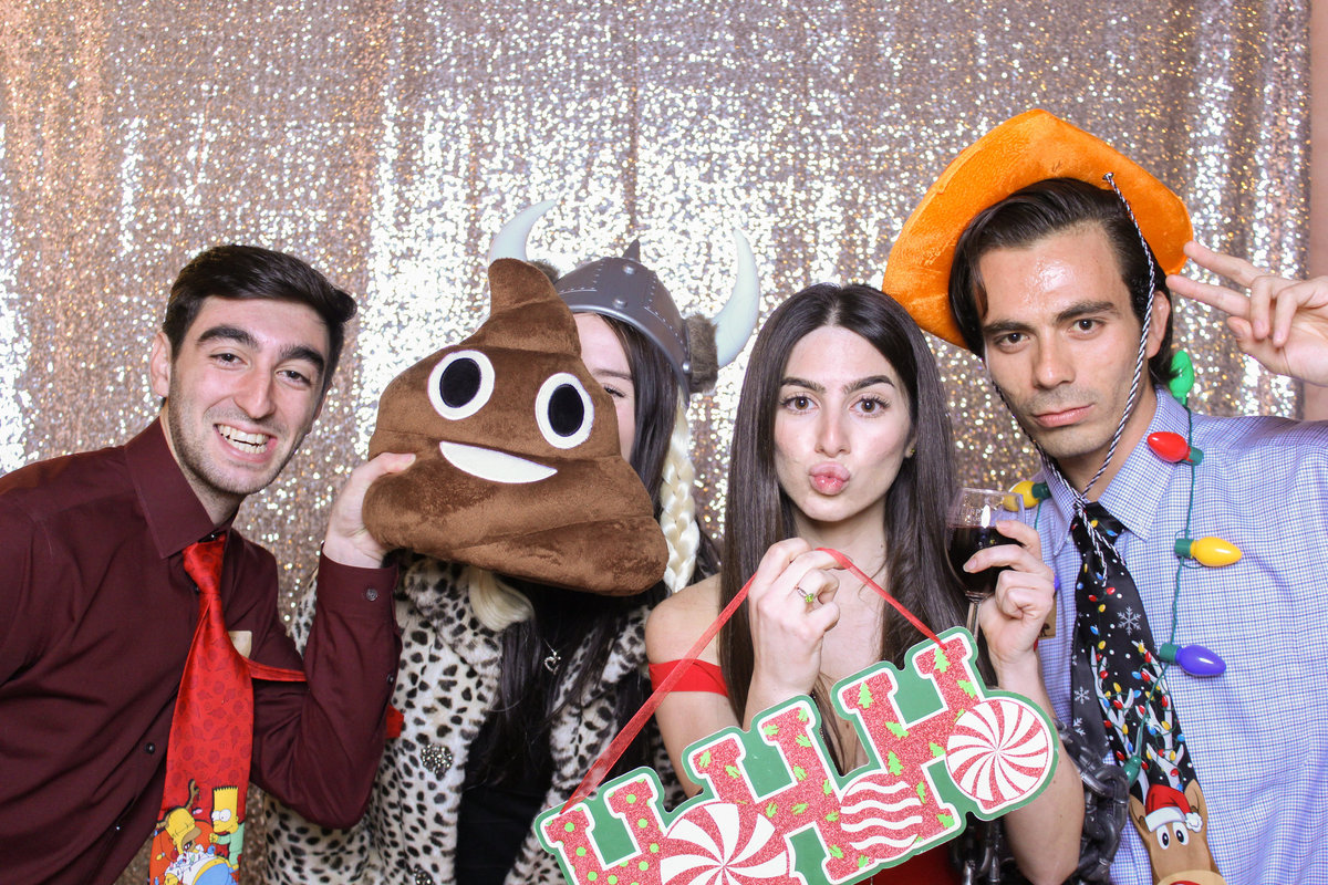 Co-workers join together in a photo booth for silly pictures at a company holiday party