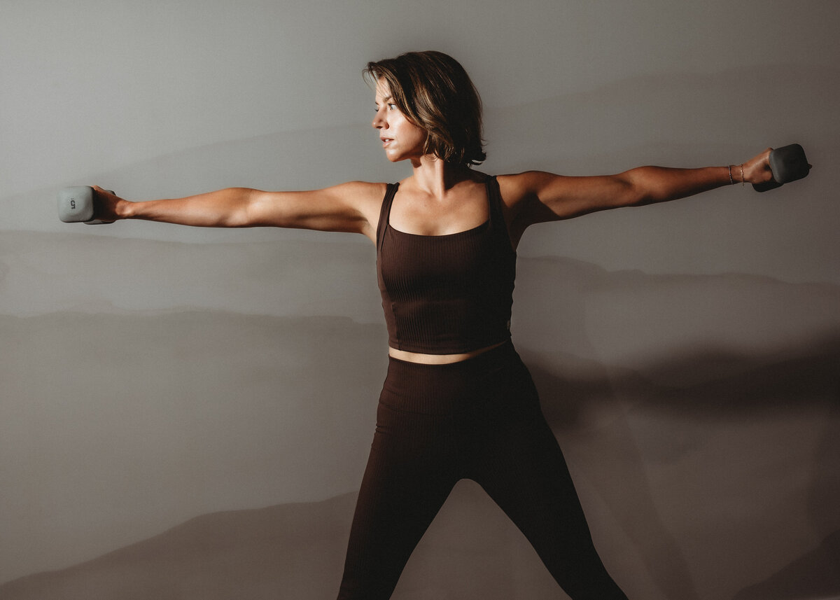 Woman lifting weights on Pilates reformer at Pilates Underground in Heber Utah