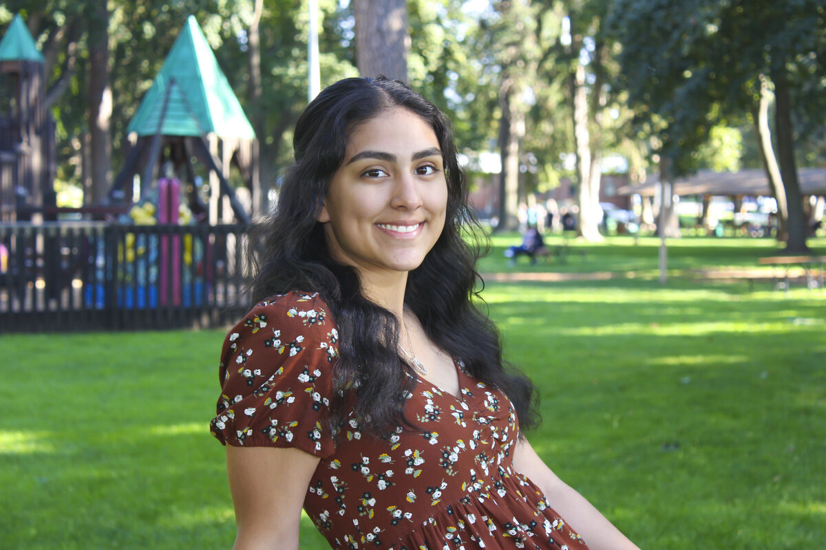 Young lady smiling with play structures in background at park