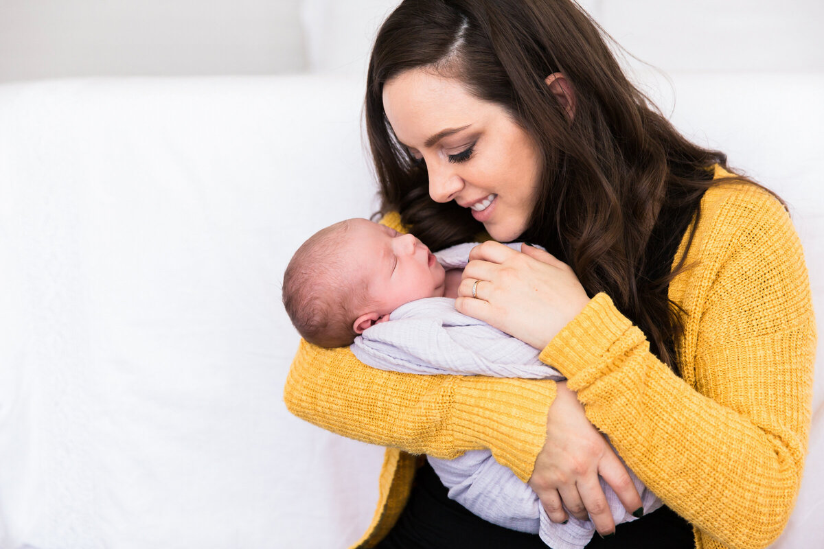 mom holding newborn baby in lifestyle Phoenix photography session