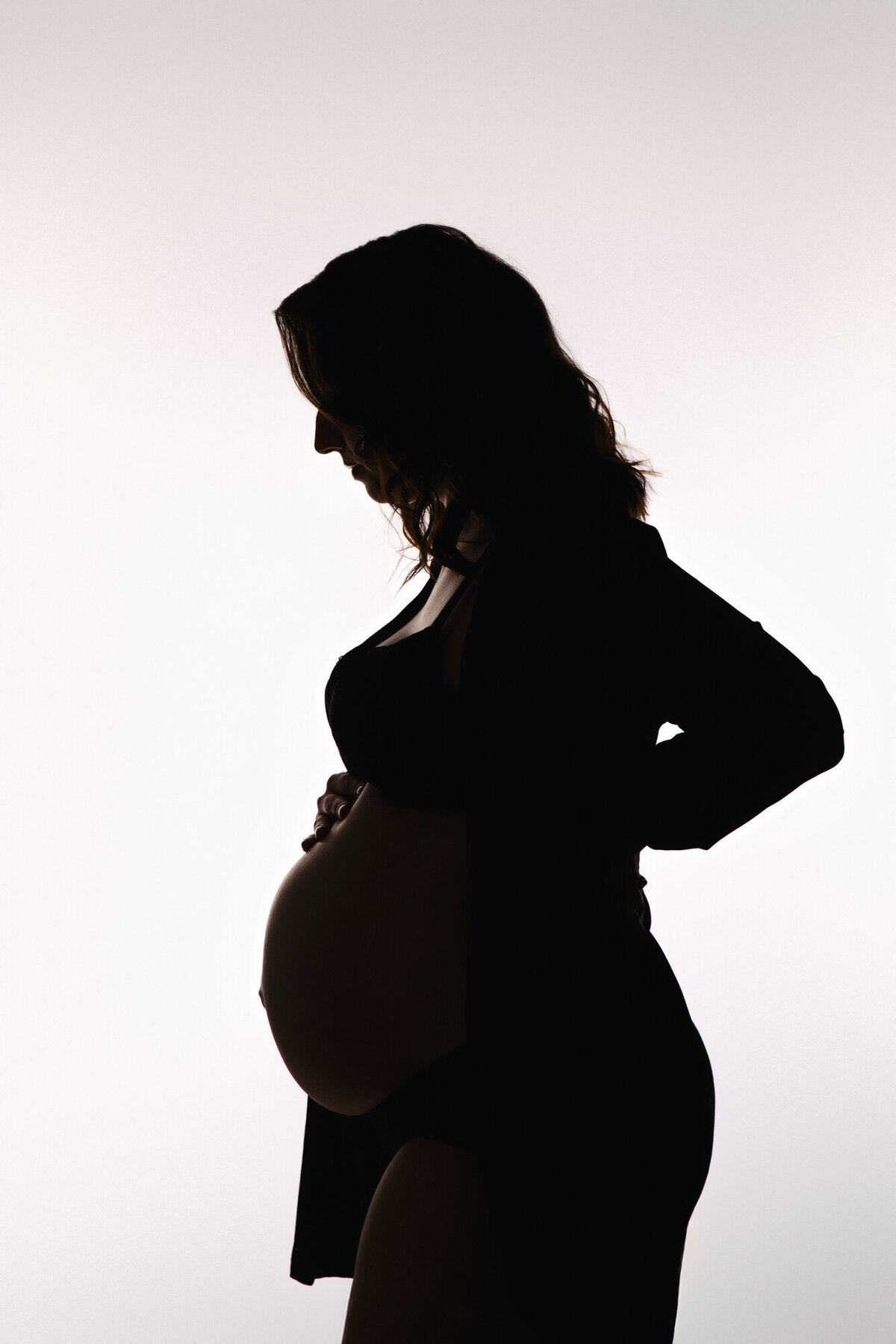 Silhouette of pregnant woman against a white background