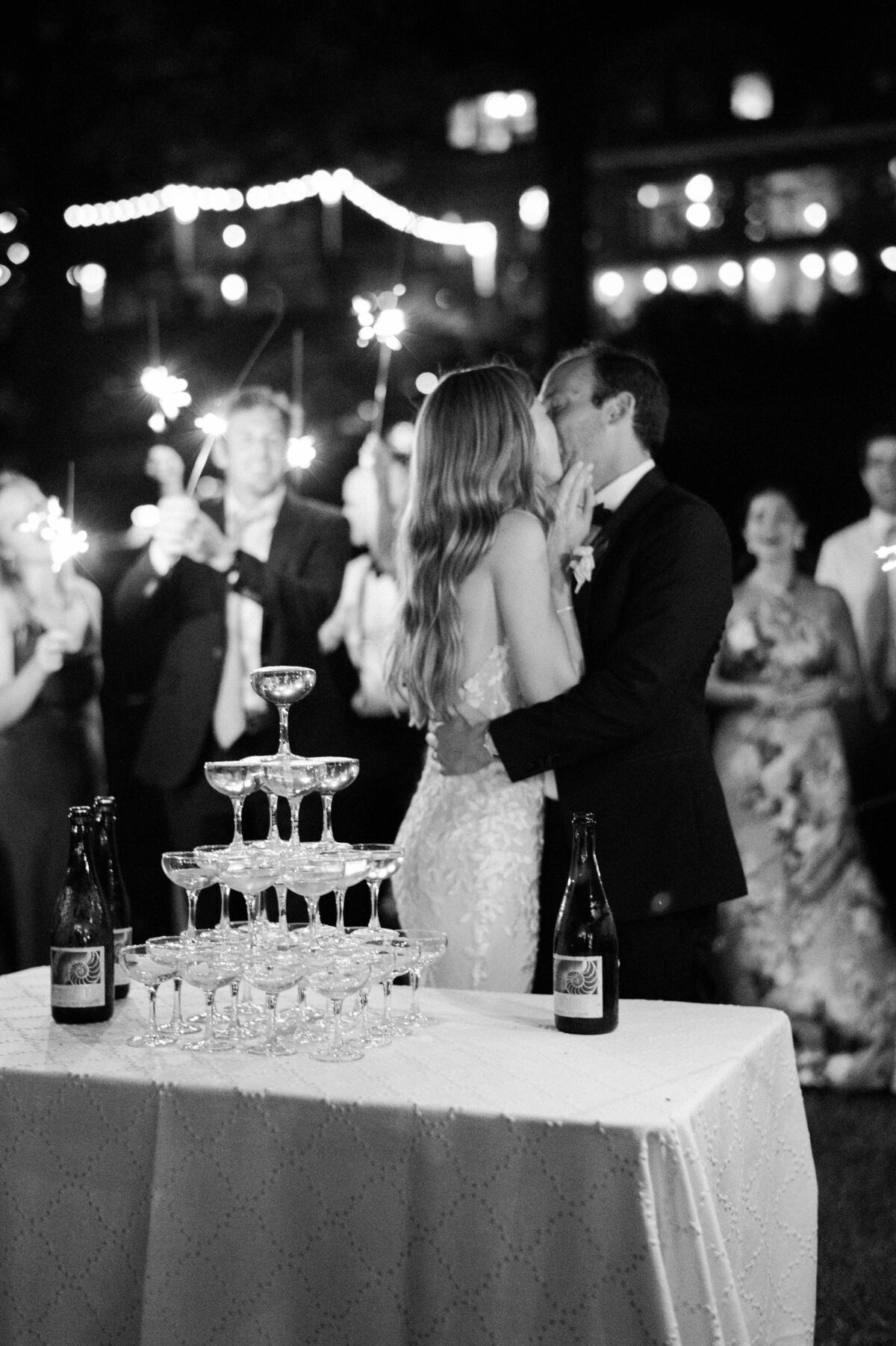 Newlyweds kiss beside their champagne tower