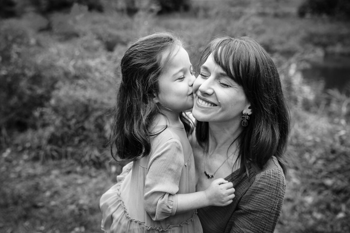 A child kisses a mom's cheek.