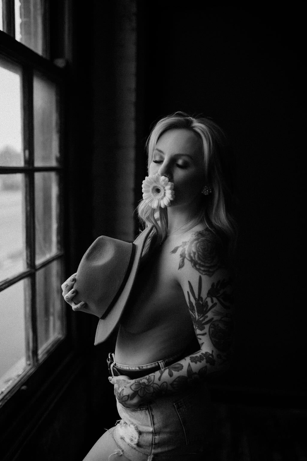 black and white image woman posing by window