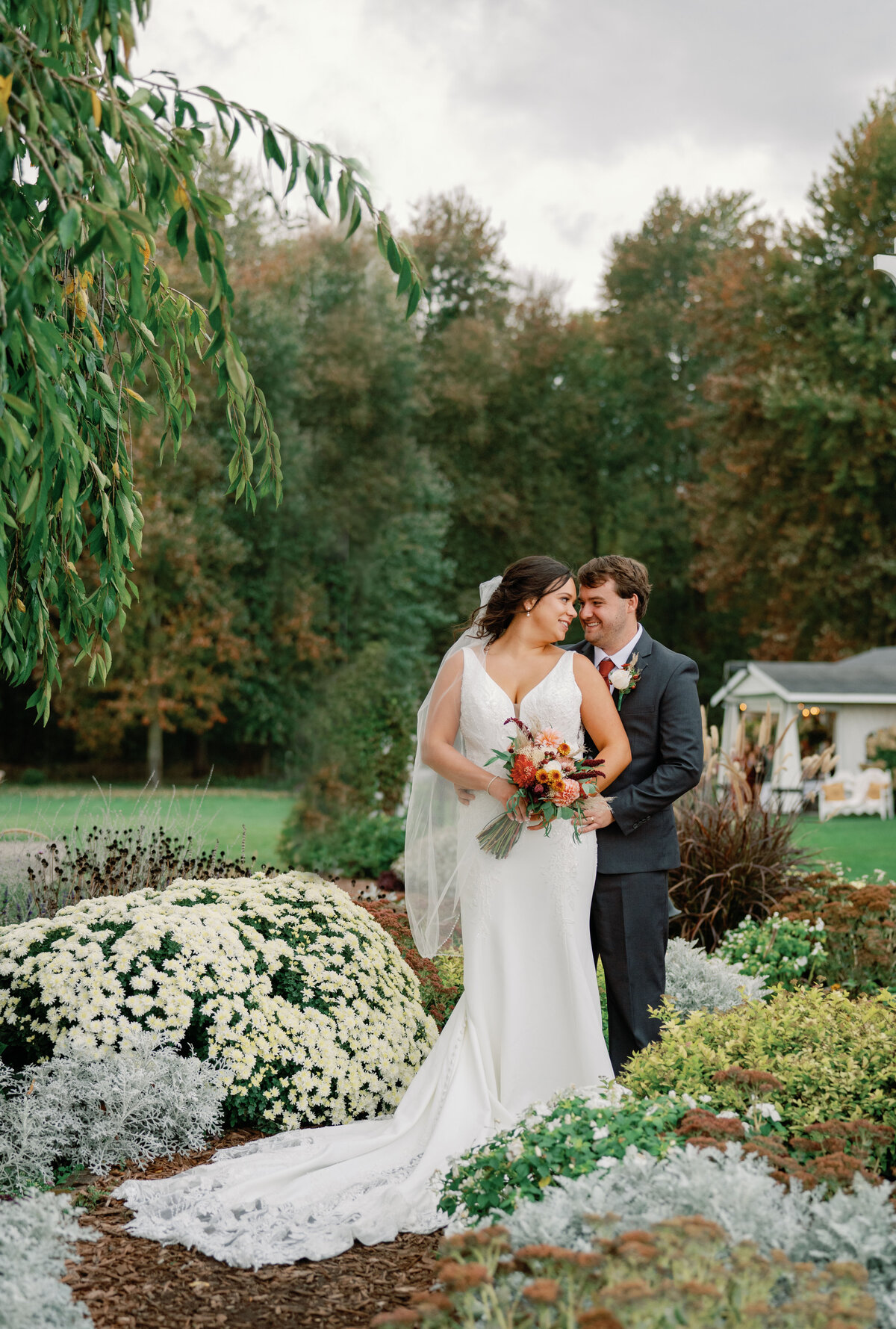 A newly married couples cuddles at their wedding at Post Family Farm by their flowers
