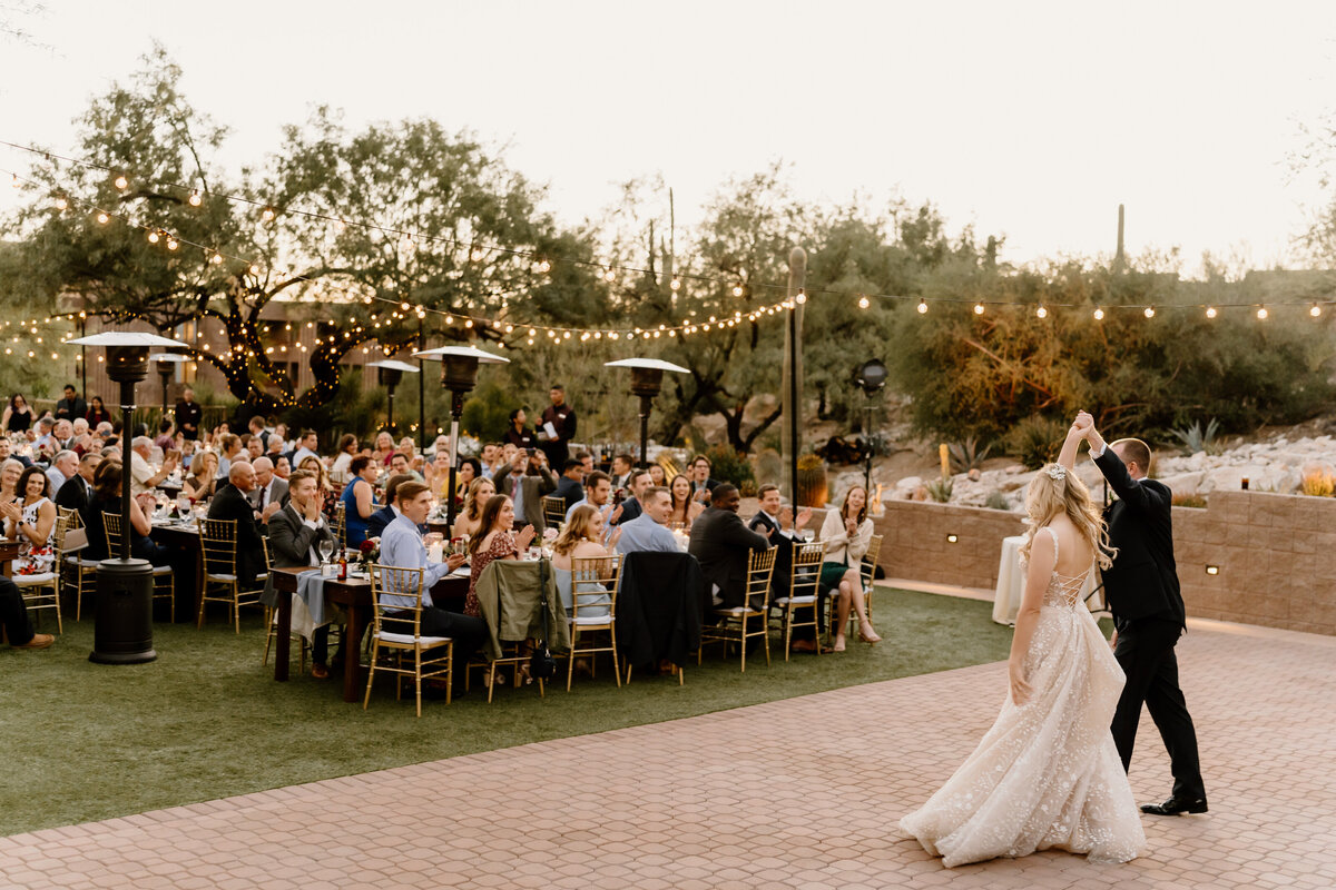 newlyweds dance under string lights at reception