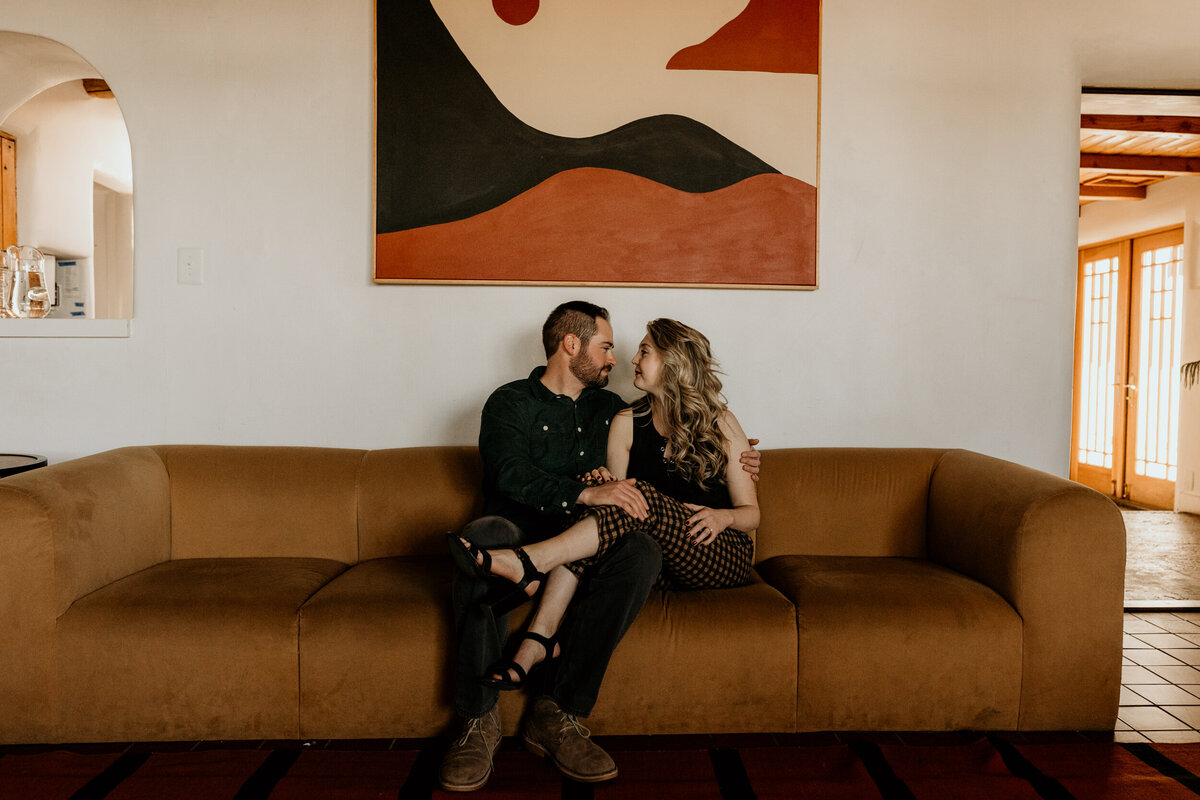 engaged couple sitting on a retro southwest couch together