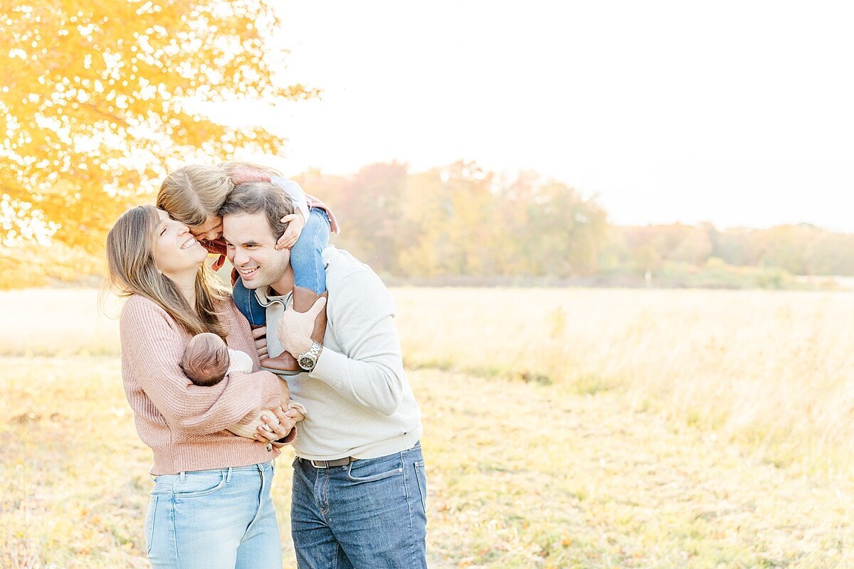 family snuggles during outdoor newborn photo session with Sara Sniderman Photography