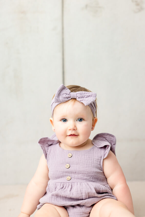One year old girl look at camera and smiles for her photos.