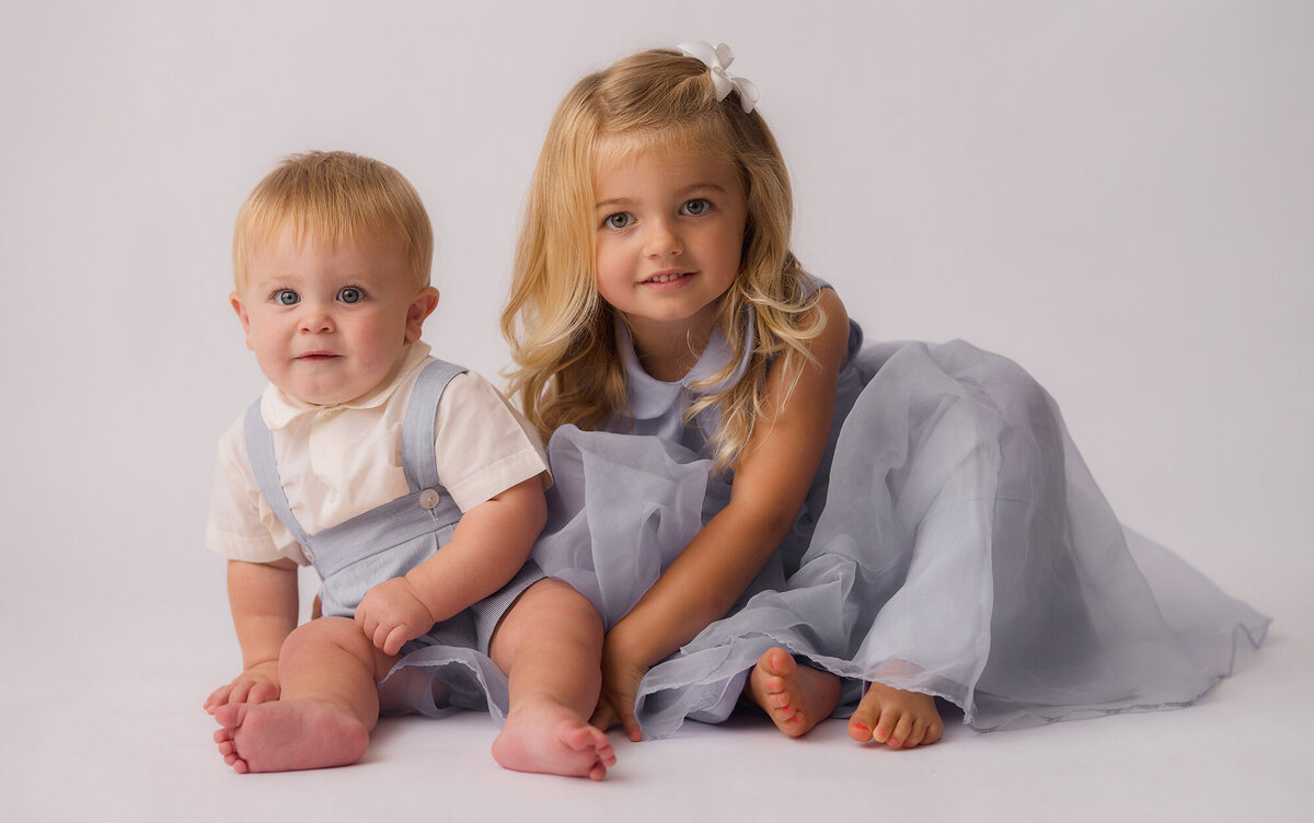 Siblings pose for Heirloom Portrait in Charleston, SC Photo Studio.