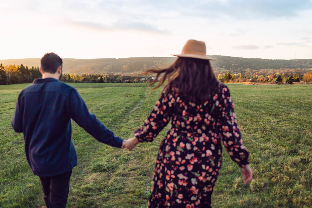 couple-holding-hands-walking in-nice-feild