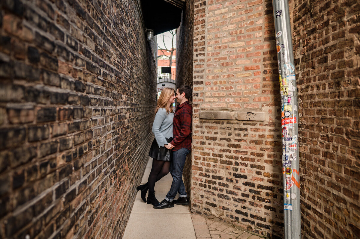 A couple stand in between the smallest alley in Chicago