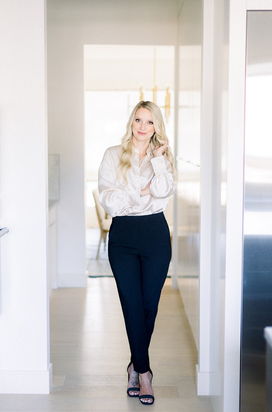 Branding photo of Calgary business woman with blonde hair standing in a light an airy hallway