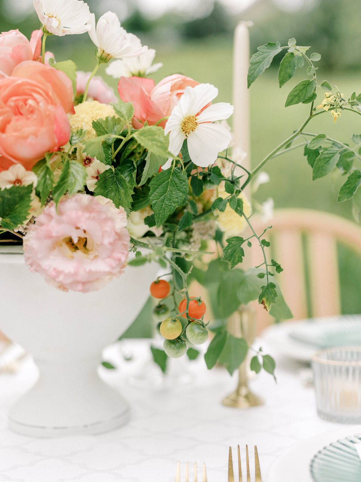 Close up of tomatoes in a pink and green fine art wedding table centerpiece in Iowa.