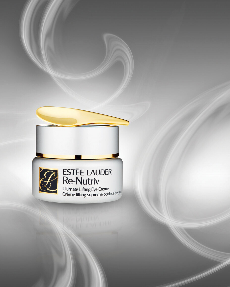 Estee Lauder perfume bottle with a luxurious design, featuring a shiny gold cap and branding.