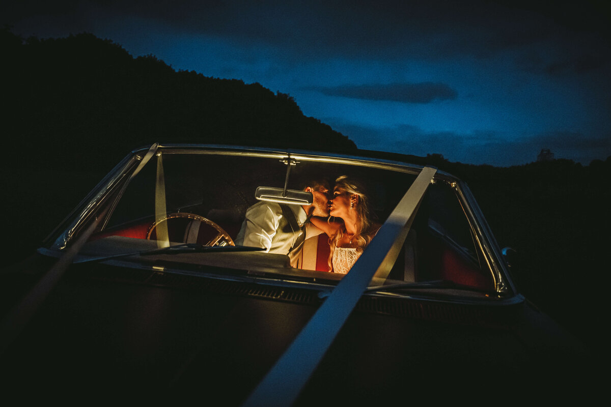 couple-kissing-classic-car-wedding