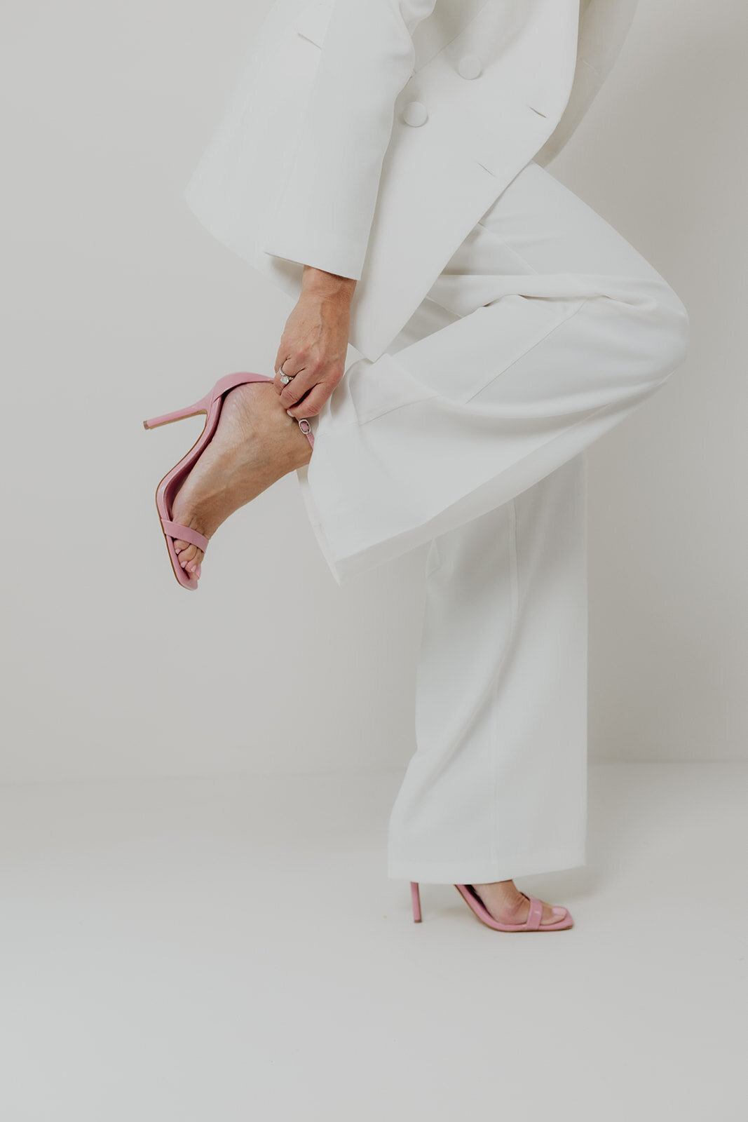 woman in white suit and pink heels