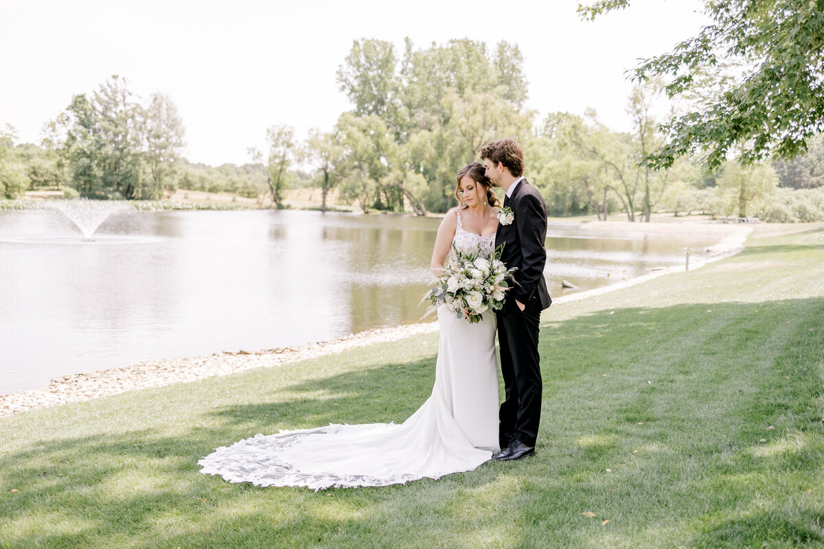 couple standing next to a pond