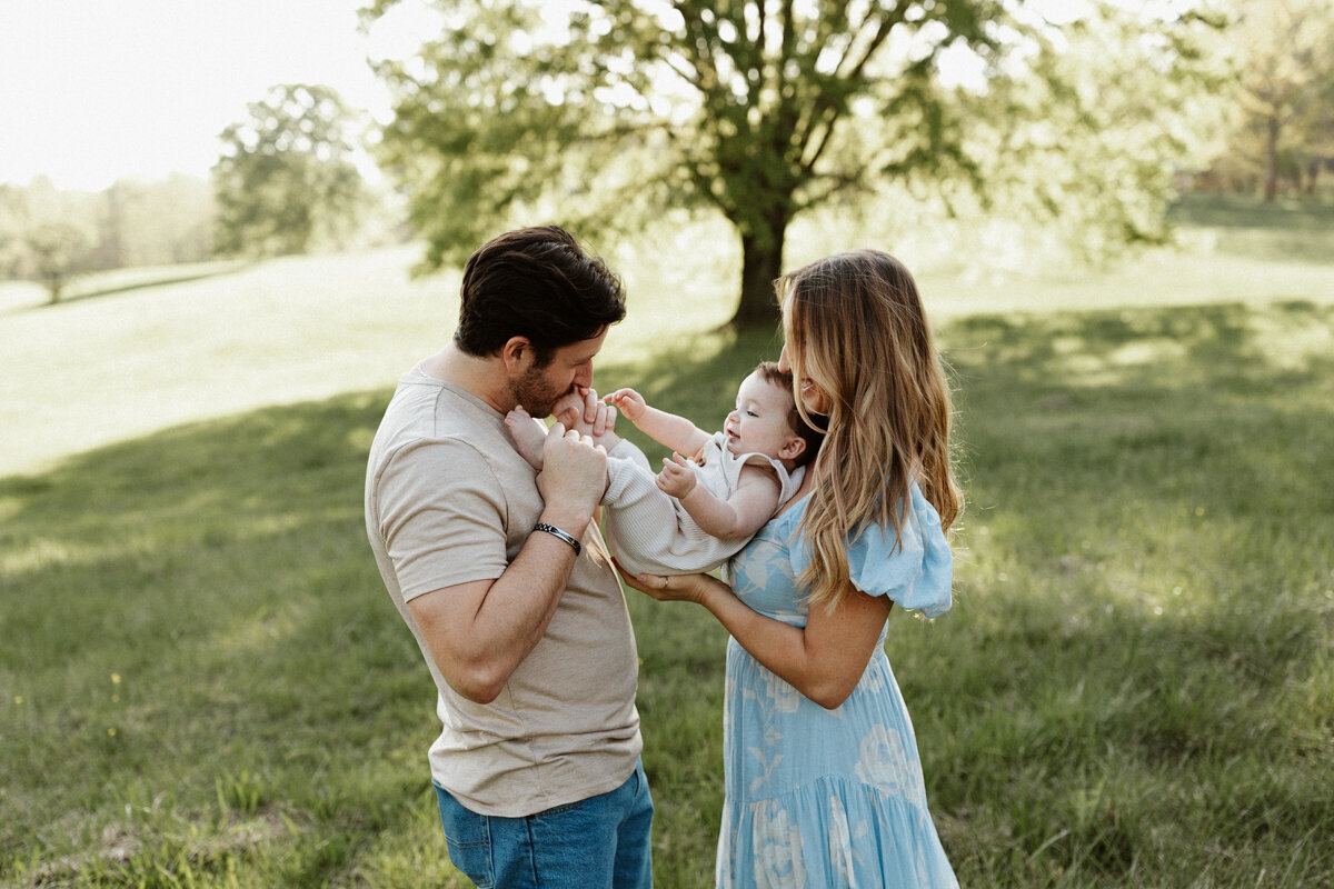 Family photography, family of four standing closely together with hands on each other