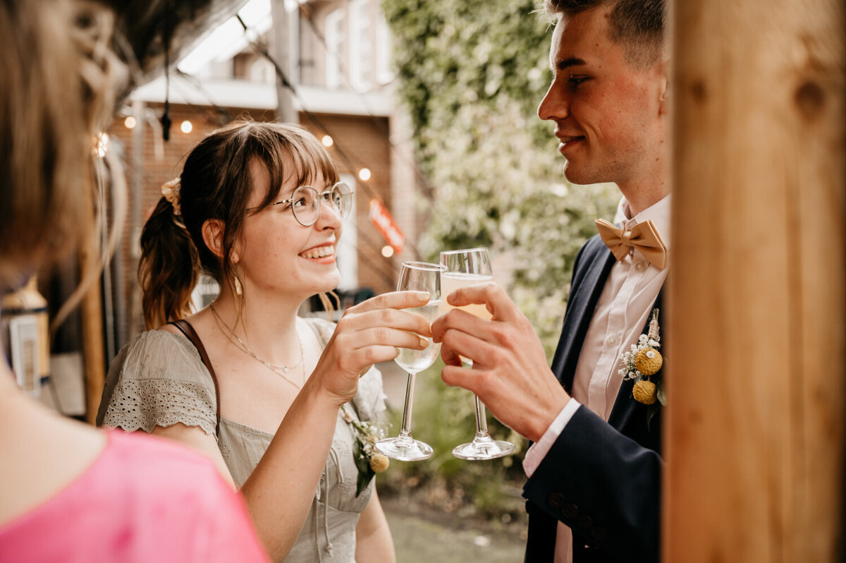 Twee daggasten proosten met champagne op een huwelijk.