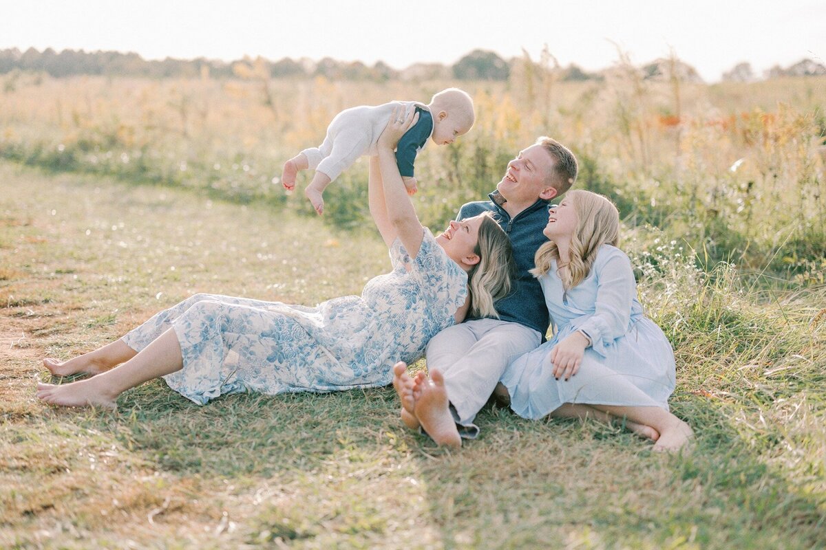 family-of-four-laying-on-ground-laughing