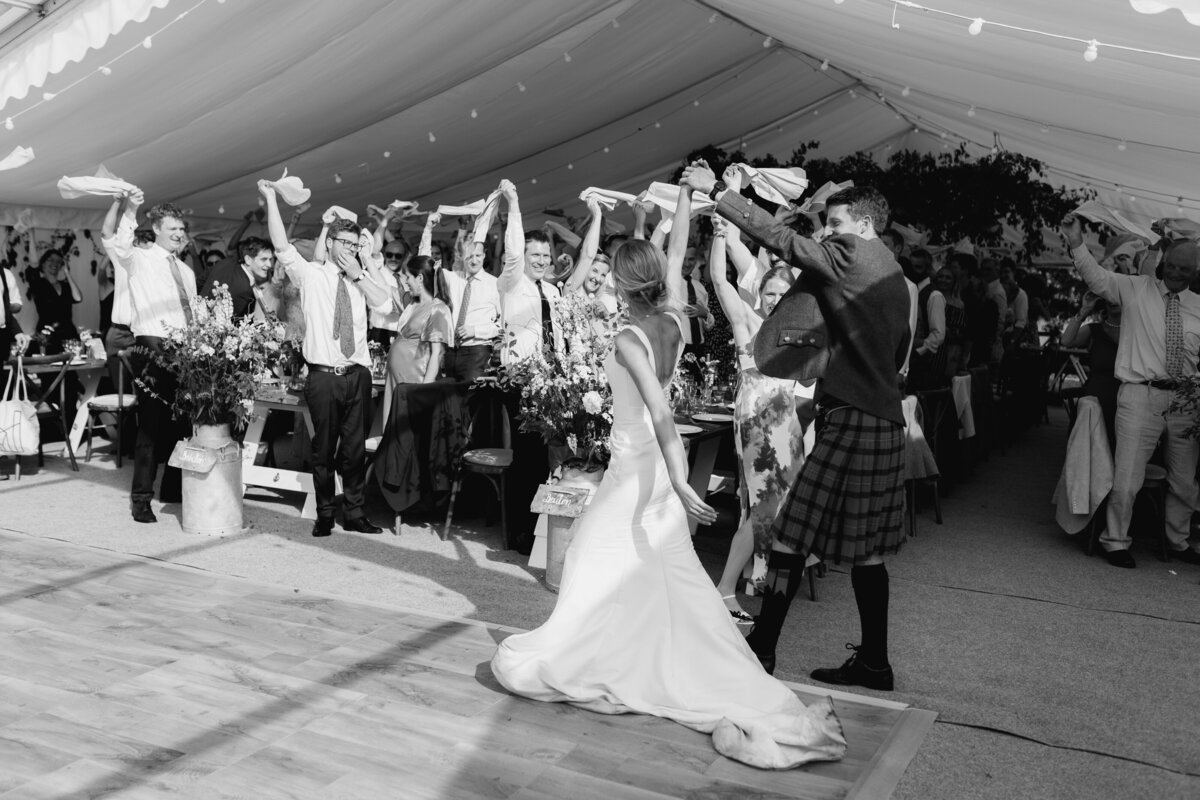 The bride and groom arrive for their Devon marquee wedding reception