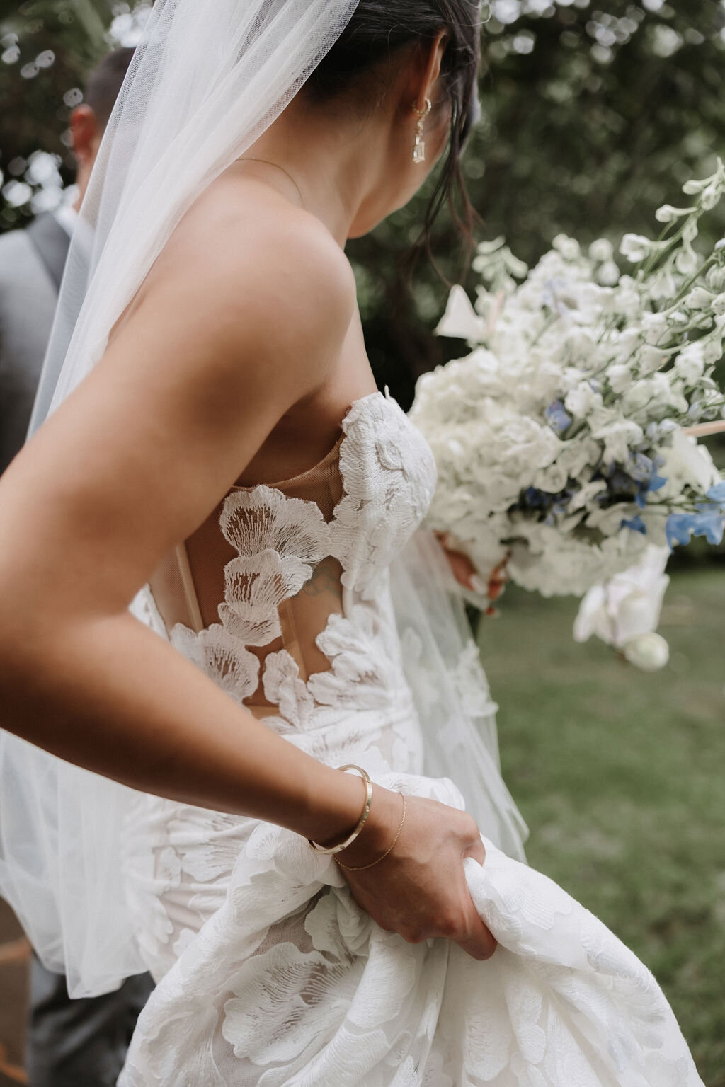 detail photo of bride's calla blanche wedding dress holding bouquet