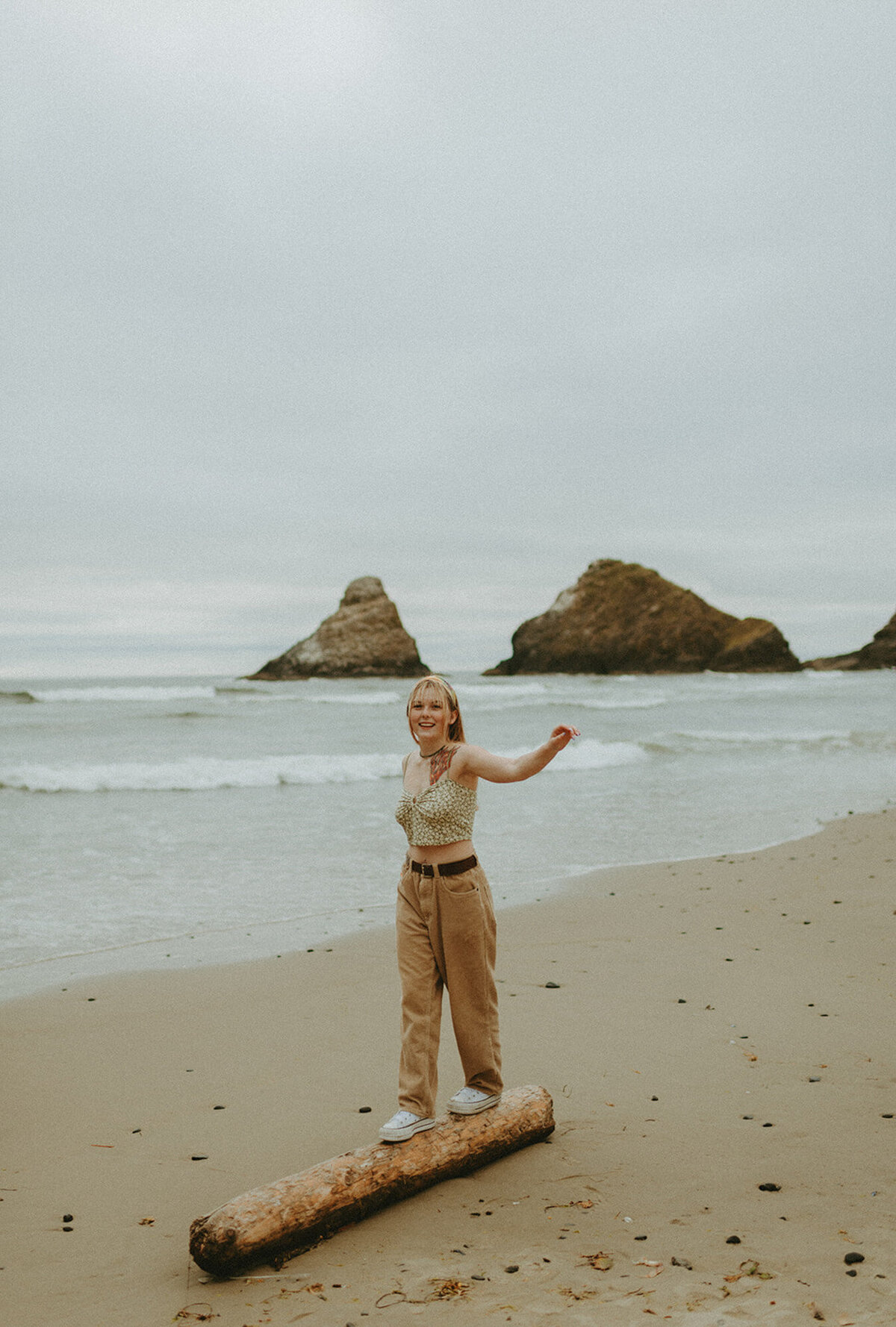 girl walking on log on the beach