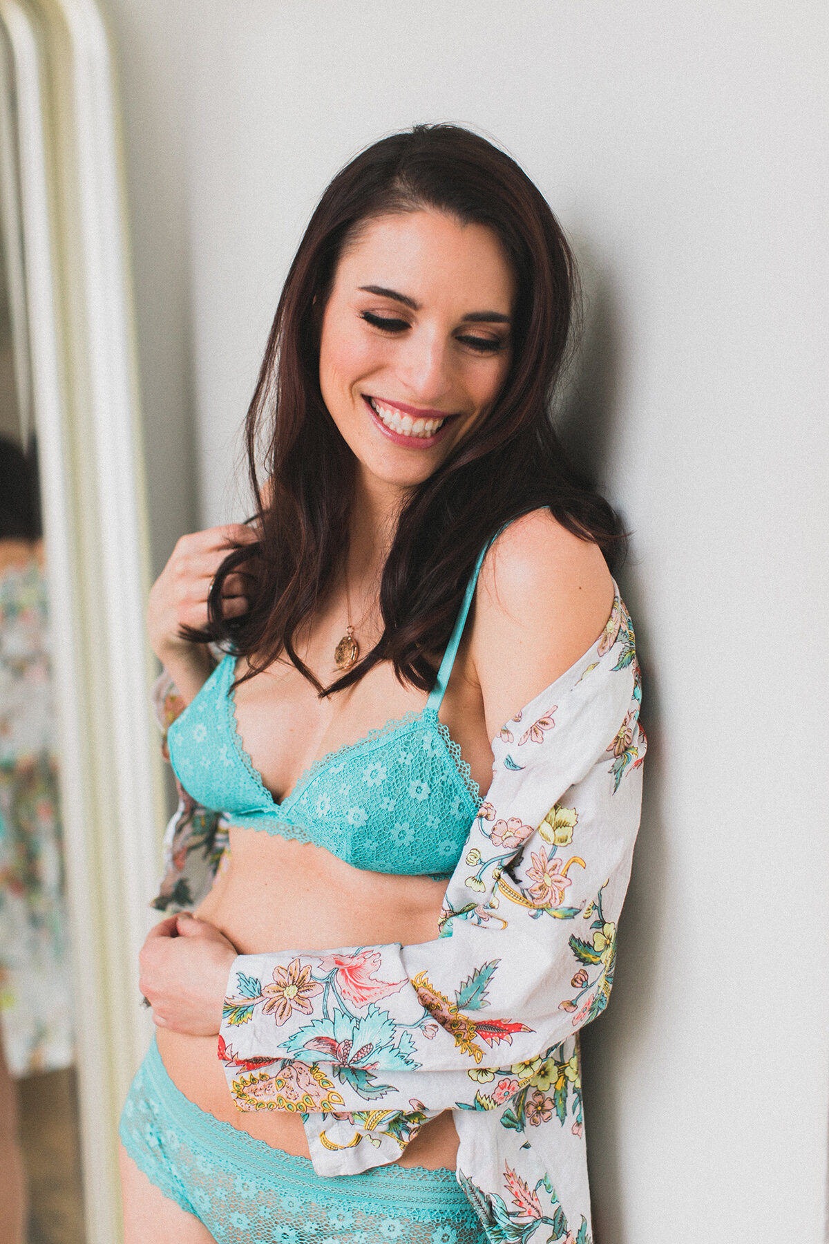 A woman poses 6 months postpartum for a boudoir session  in Chicago to celebrate her body