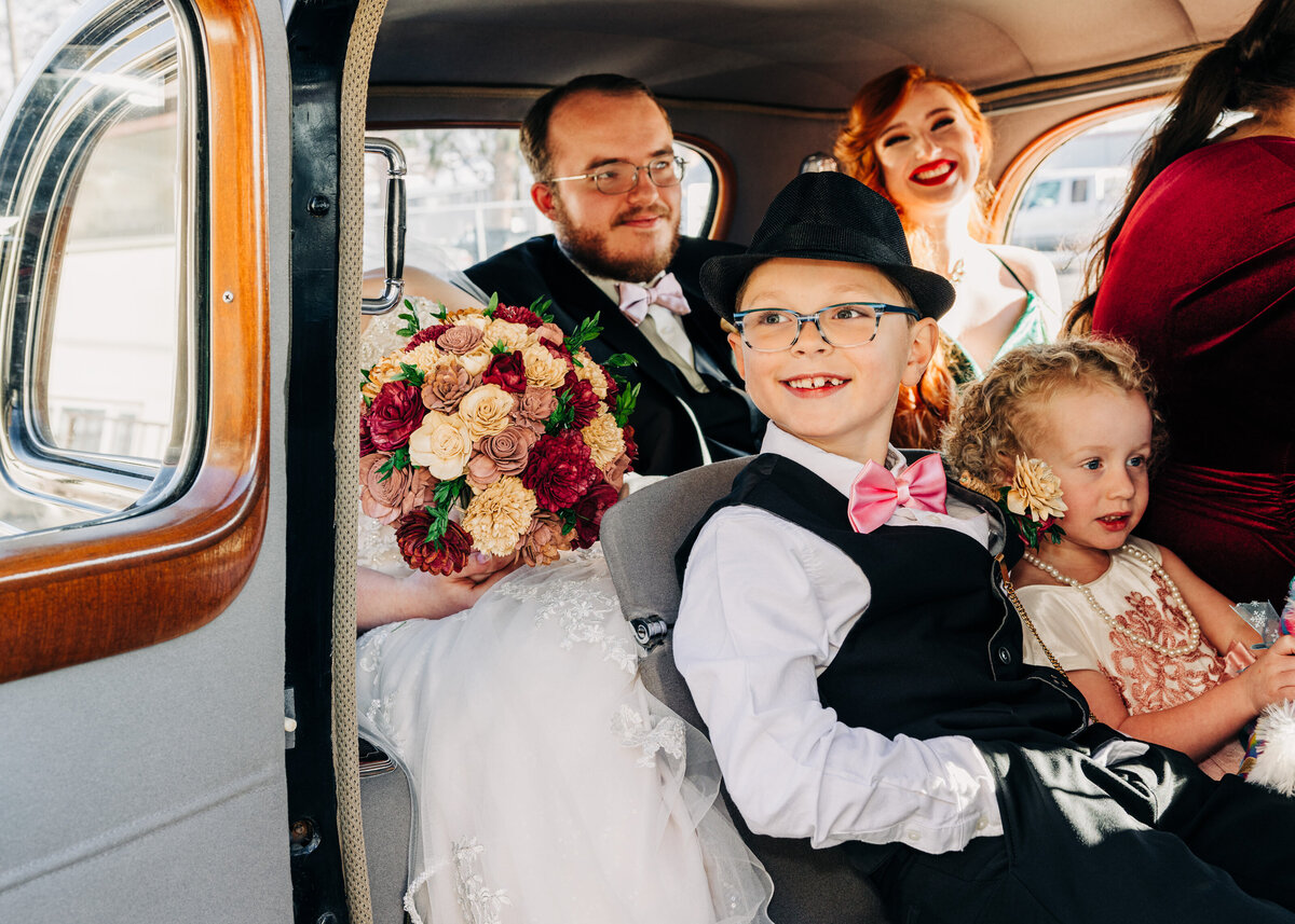 Bridal party in antique limousine at Hamilton Assembly of God church, Montana