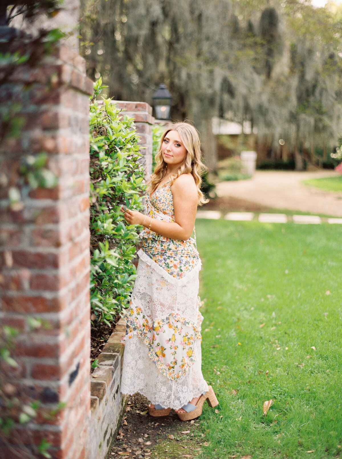 A senior portrait surrounded by the enchanting flowers and historic charm of The Myrtles Plantation, beautifully captured on film by Morgan Alysse, Louisiana film photographer.