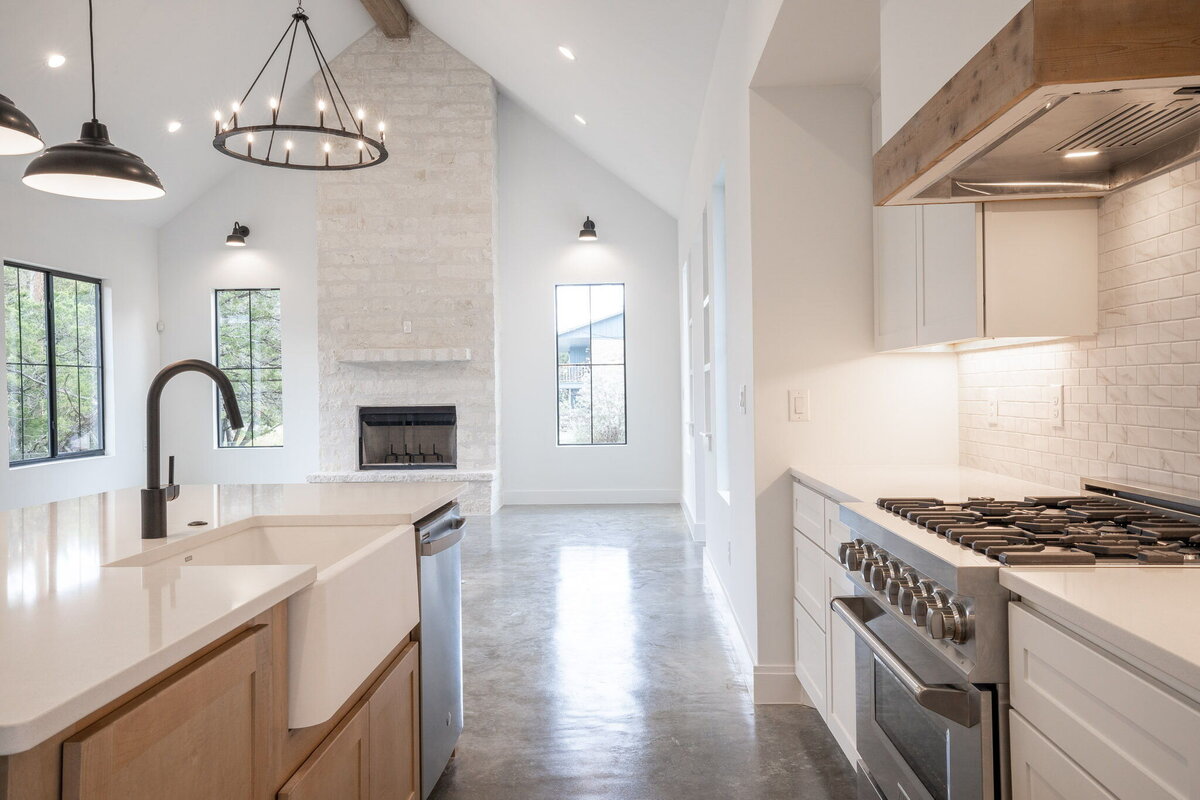 white countertop on kitchen island with wood cabinets and black pendant lights