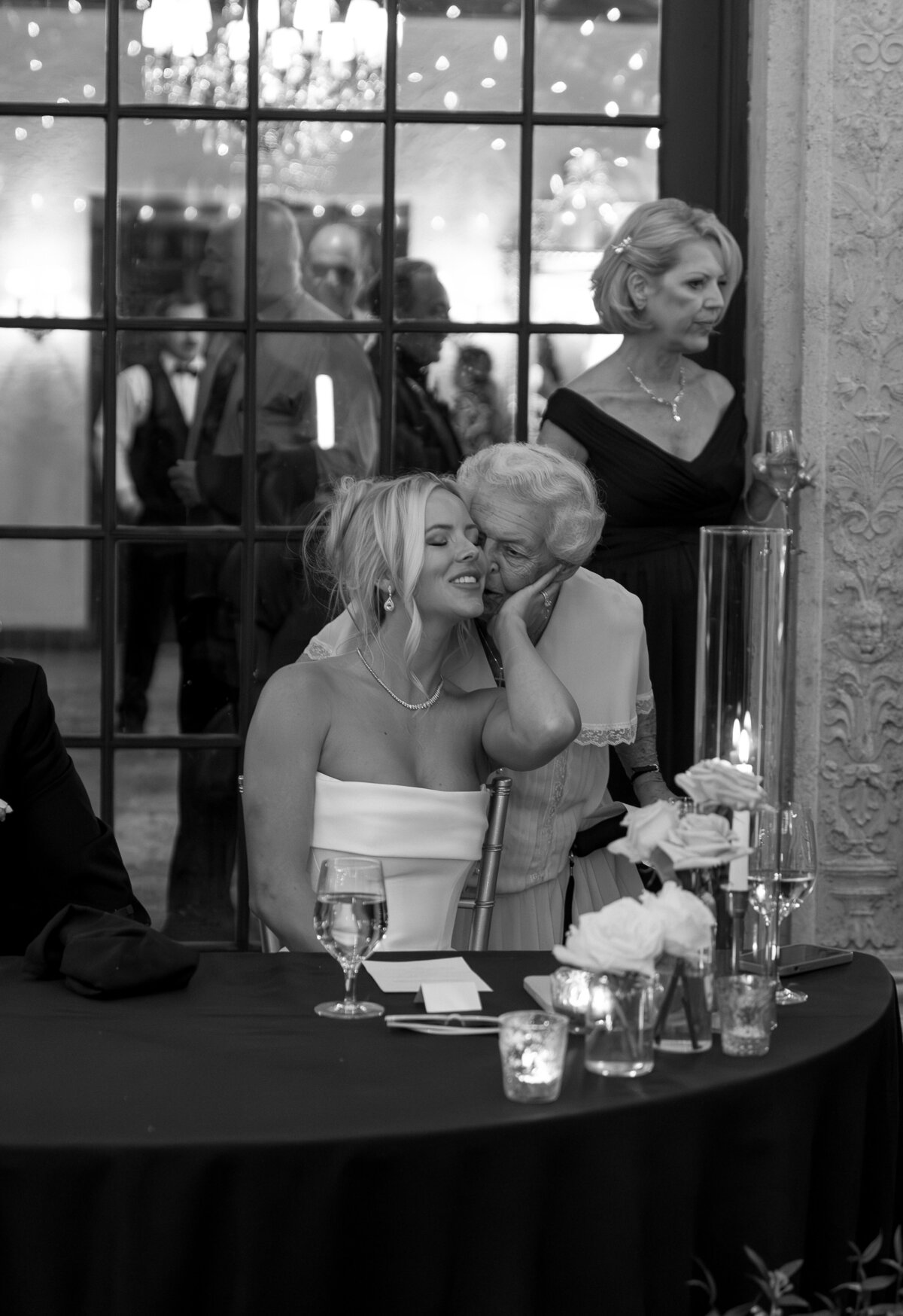 Grandmother kissing bride on cheek at wedding reception by film wedding photographer Shelby Ann Photos