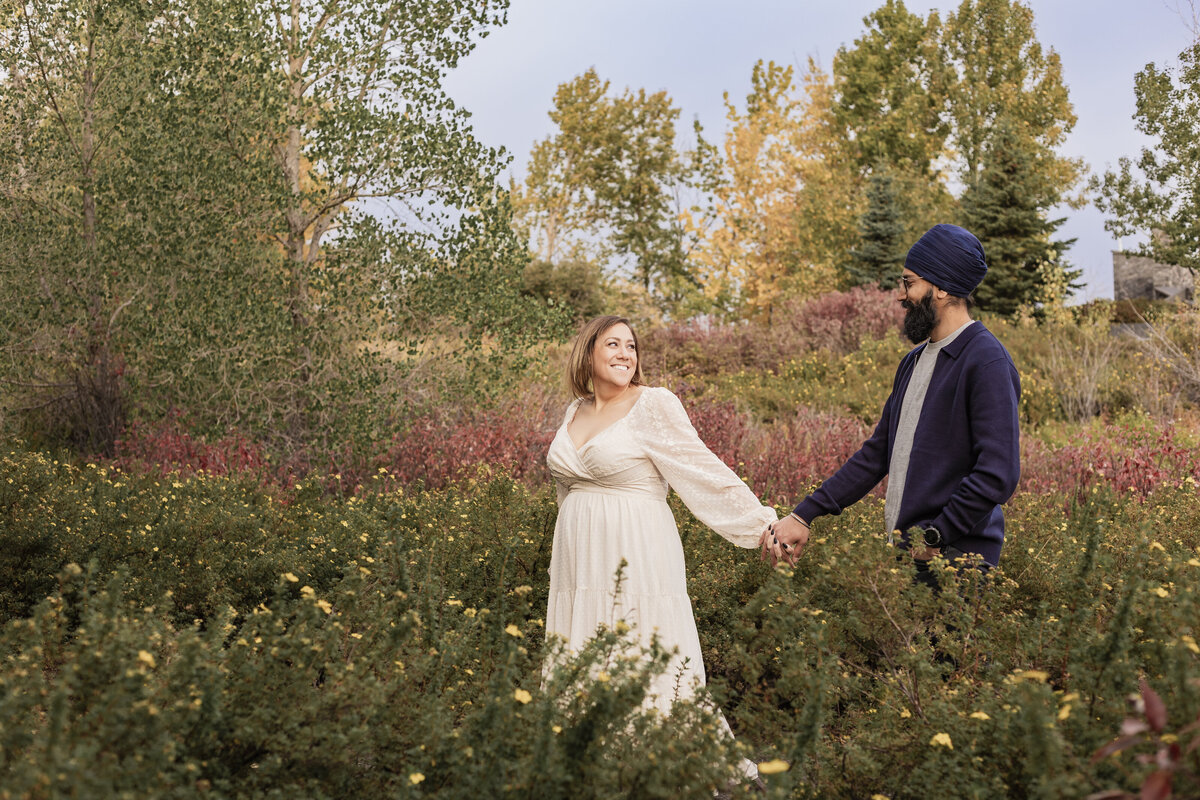 An engaged couple holding hands and staring at each other