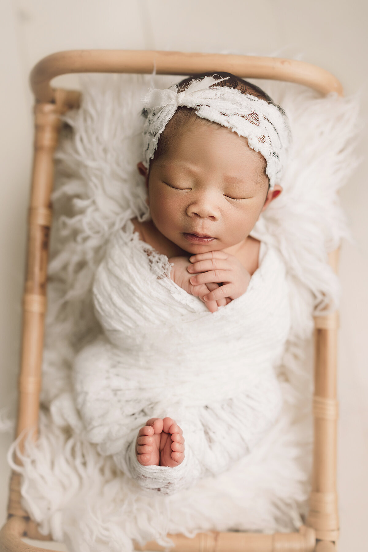 White lace wrap on a baby girl laying in a basket