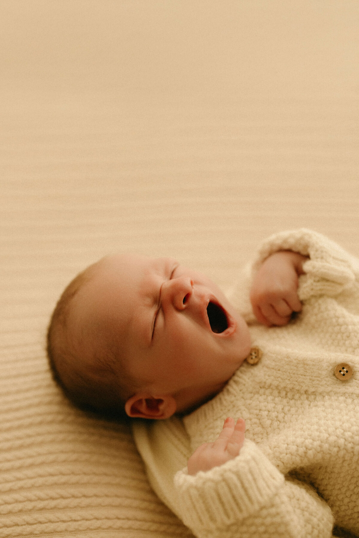 Baby wrapped in textured neutral blanket during Nashville TN newborn studio shoot