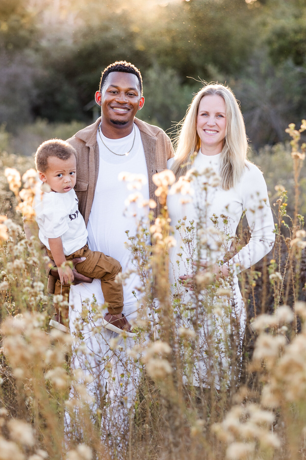 family standing in tall grass san diego