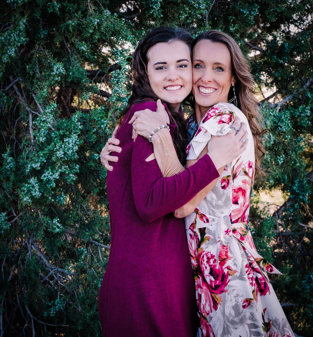 Mom and daughter hug in front of tree in Prescott family photography session
