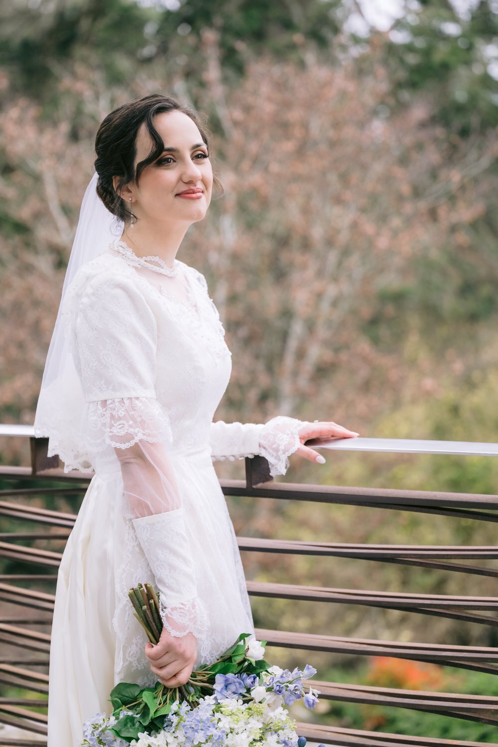 bride gazing into distance at deck railing 