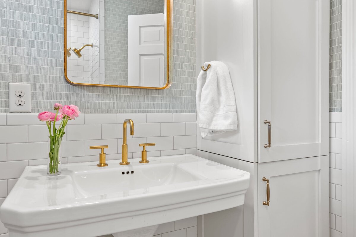 the keeping room interiors oakview guest bathroom with pink flowers in case and gold framed mirror