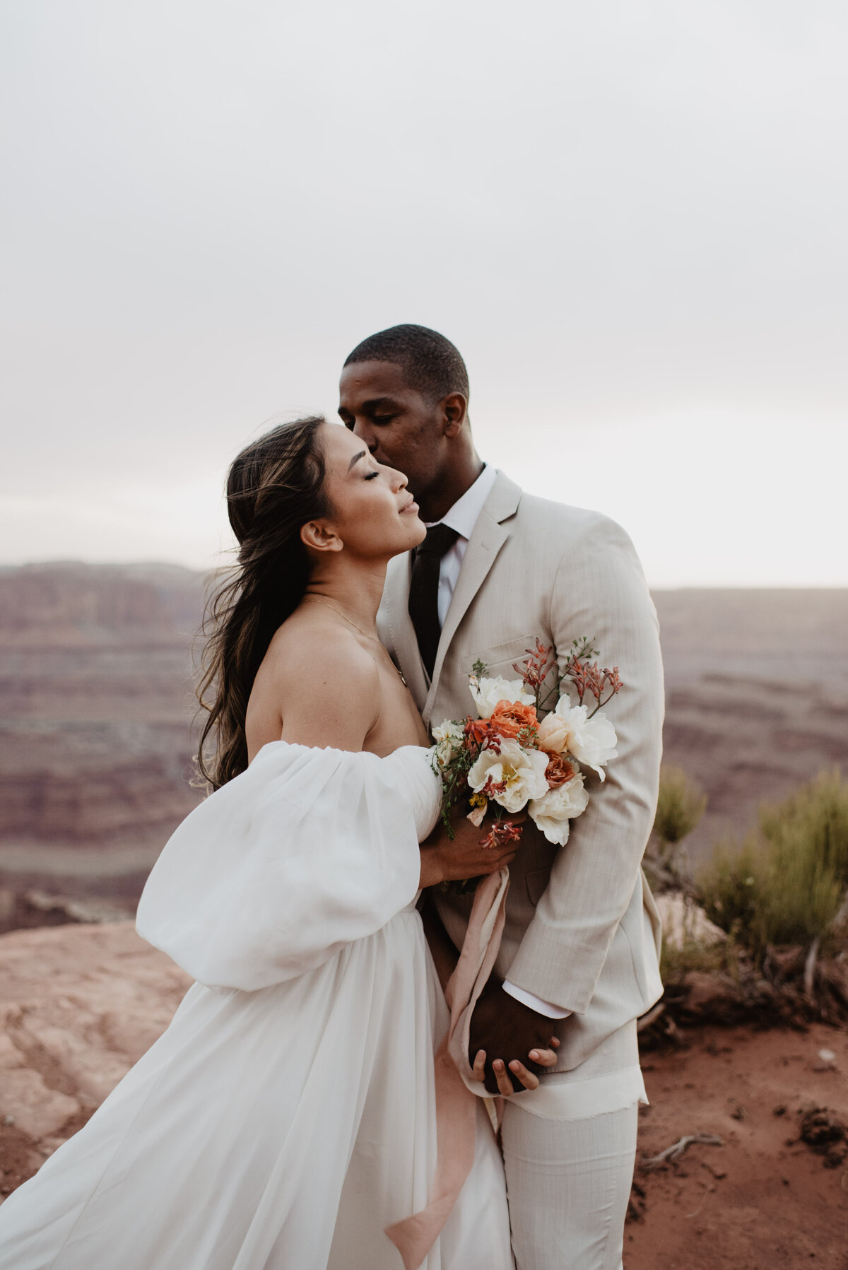 Utah Elopement Photographer captures groom kissing bride during golden hour portraits