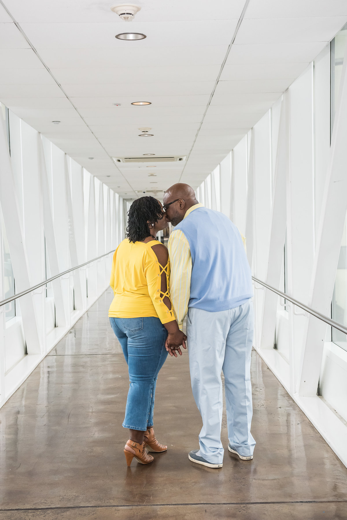 couple kissing in a white hallway