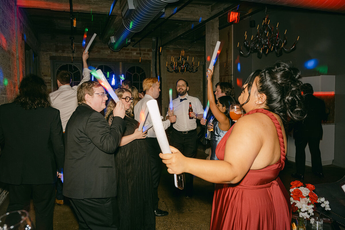 Flash-style capture of luxury wedding guests dancing in San Antonio firehouse after party