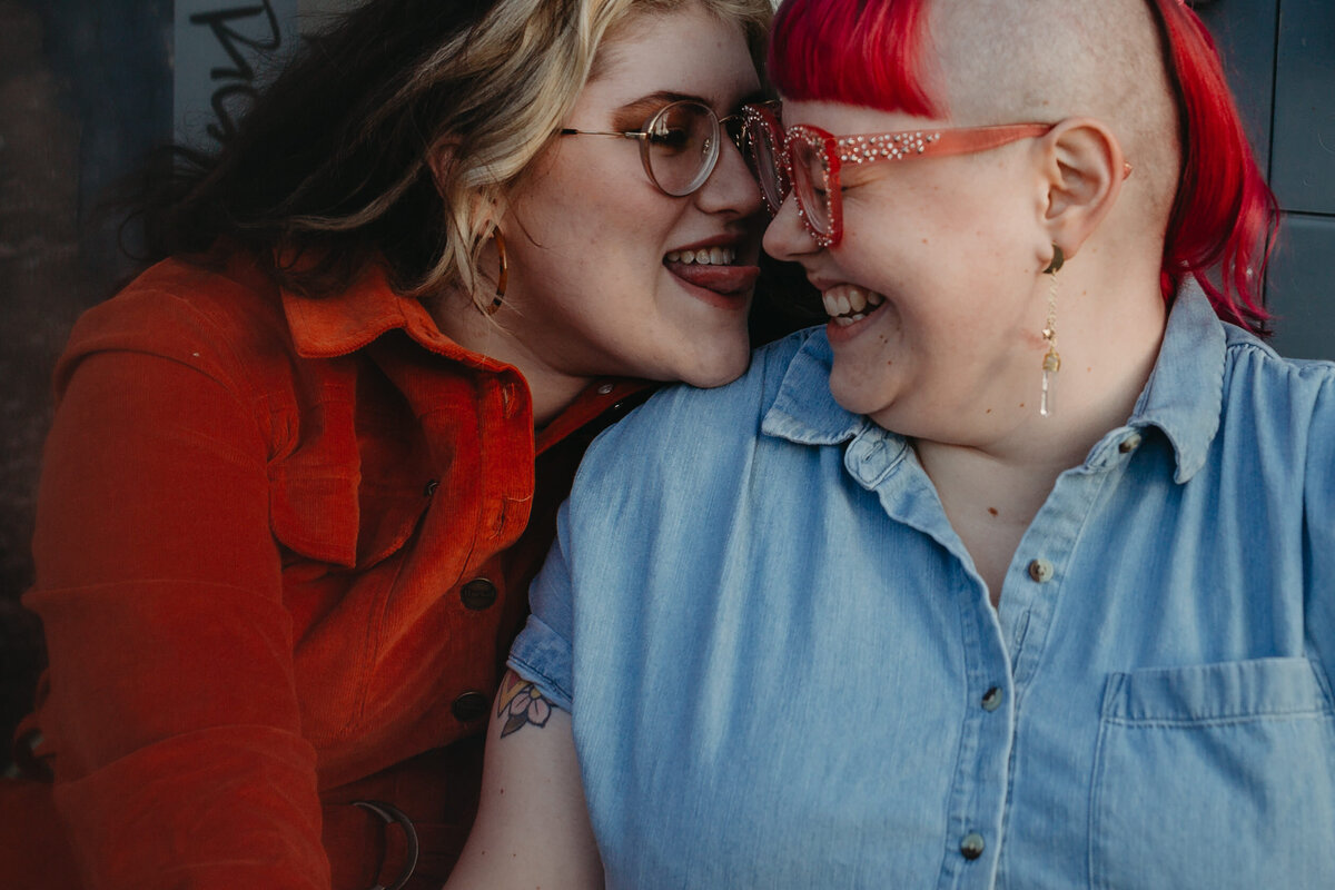 Two people sharing an intimate moment, with one wearing glittery glasses, captured in a candid and joyful close-up