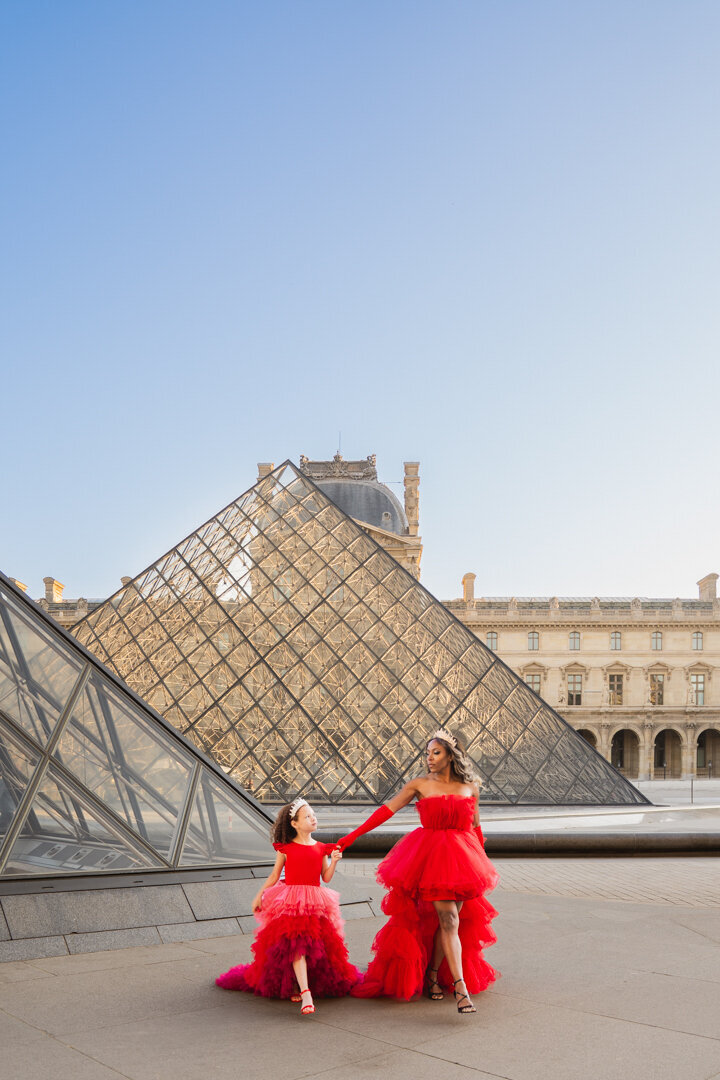 Paris sunrise mommy and me photoshoot at the Louvre with red and pink princess dresses and crowns
