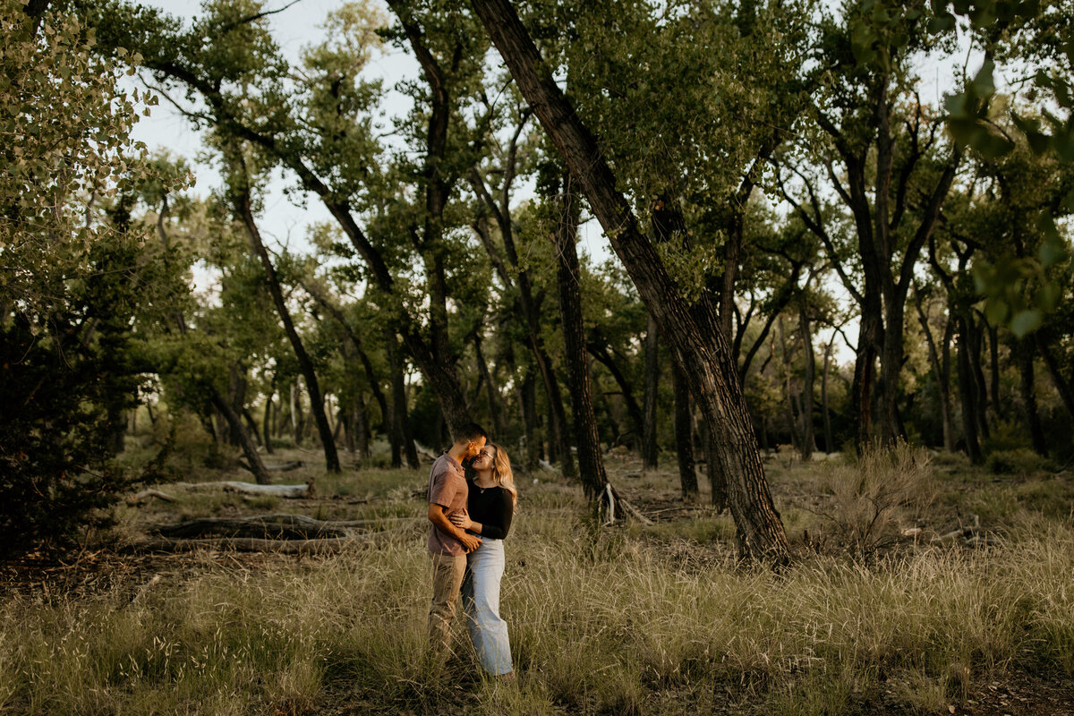 engaged standing together in the Bosque in Albuquerque