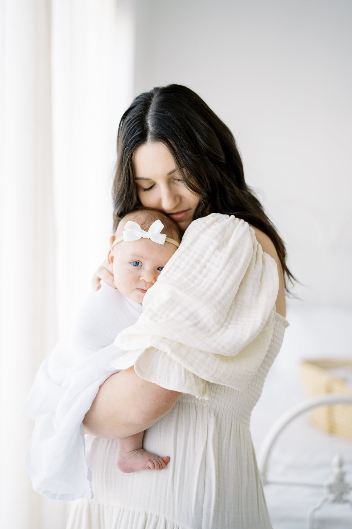 mom snuggling newborn baby