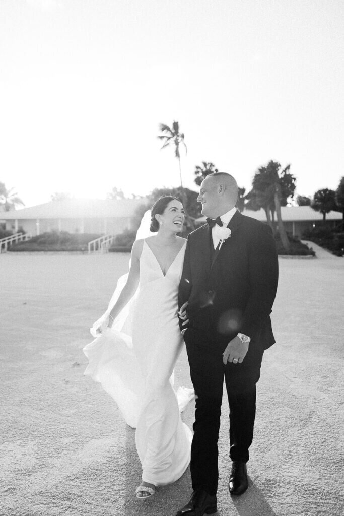 A romantic black-and-white candid of the bride and groom walking together, glowing with happiness after saying "I do." Destination wedding photography by Claudia Amalia Photography in the Florida Keys.