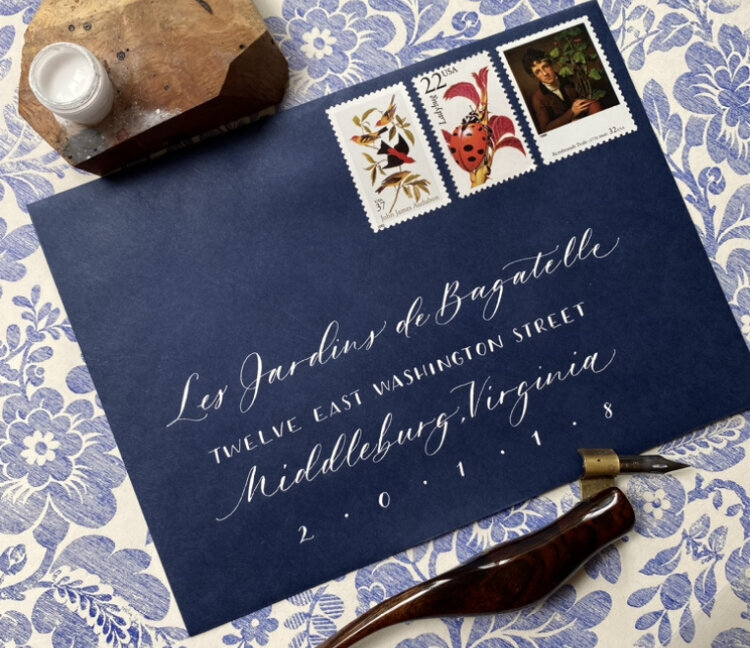 Custom calligraphy in a blue envelope with stamps