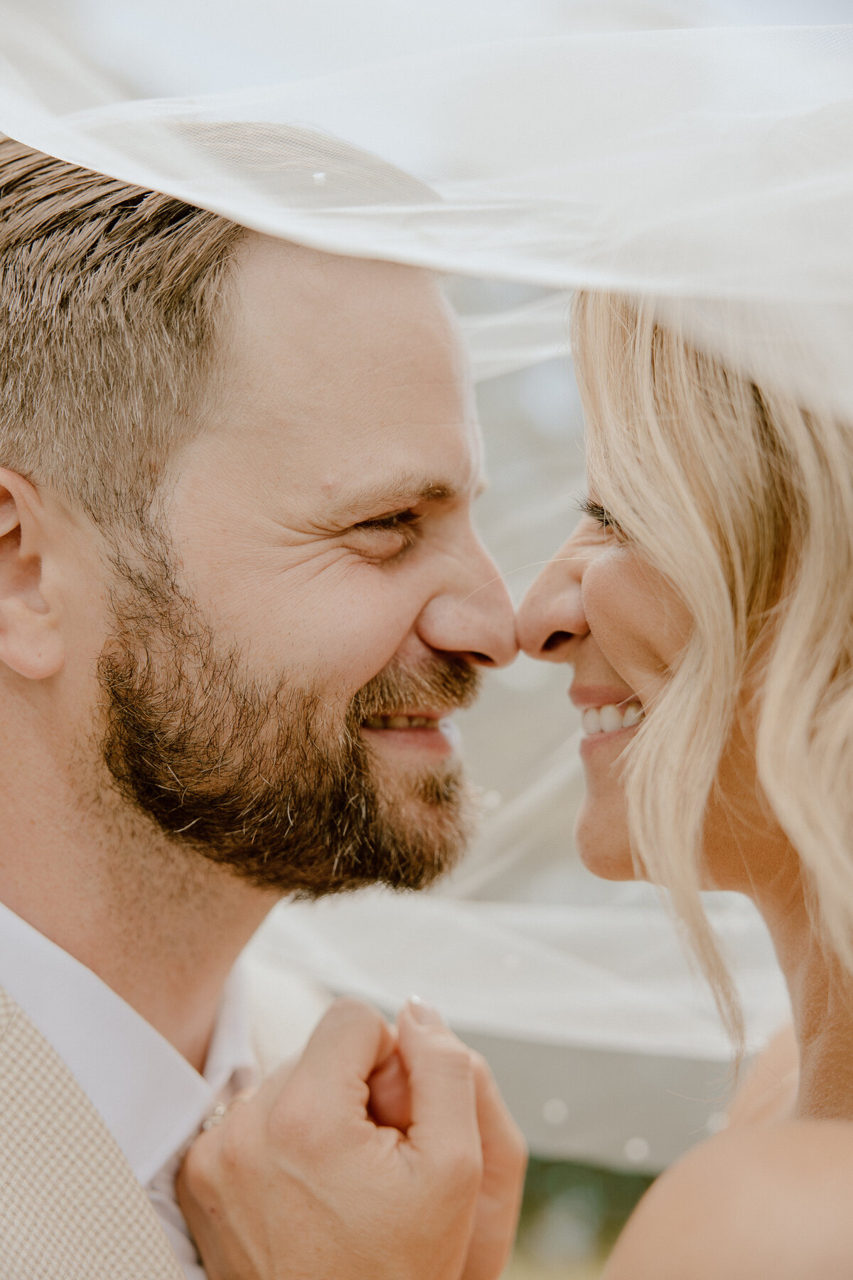 bride and groom under veil during ohio wedding